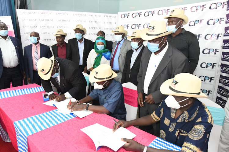 Kisumu Governor Anyang Nyong'o and Laptrust CEO Hosea Kili sign a memorandum of understating on the Sh3.8 billion affordable housing project in Kisumu on Tuesday.