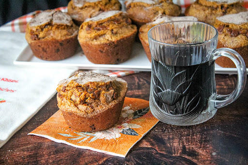 Cinnamon Chip Pumpkin Muffin on a napkin with a cup of coffee.