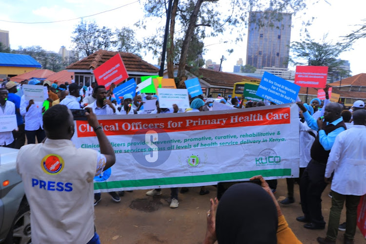 Healthcare workers hired by government under the Universal Healthcare program hold placards as they demonstrate on April 8, 2024.