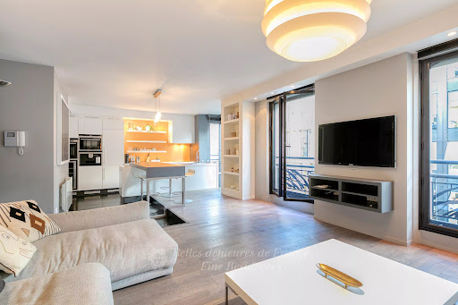 Modern living room with open kitchen and island in this luxury apartment / penthouse for sale in Paris 8ème ($2,090,874 - 93 m²)