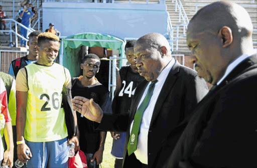 SCOUTS HONOUR: Coach Shakes Mashaba, centre, with fellow coach Khabo Zondo, speaking to a group of players during the Ke Yona trials held at the Sisa Dukashe Stadium in Mdantsane Picture: MICHAEL PINYANA