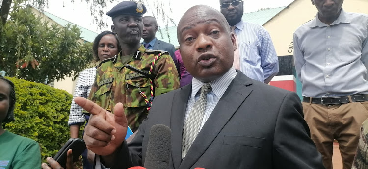 Kisii County Commissioner Tom Anjere with regional security team during a press conference outside his office Wednesday afternoon. He fingered politicians for the bodaboda violence in the region (IMAGE BY MAGATI OBEBO)