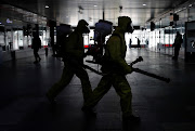 Russia's Emergencies Ministry members wearing protective gear walk to spray disinfectant while sanitizing the Leningradsky railway station amid the outbreak of the coronavirus disease (COVID-19) in Moscow, Russia May 19, 2020. 
