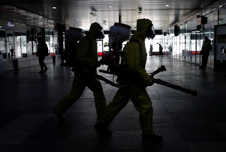 Russia's Emergencies Ministry members wearing protective gear walk to spray disinfectant while sanitizing the Leningradsky railway station amid the outbreak of the coronavirus disease (COVID-19) in Moscow, Russia May 19, 2020.