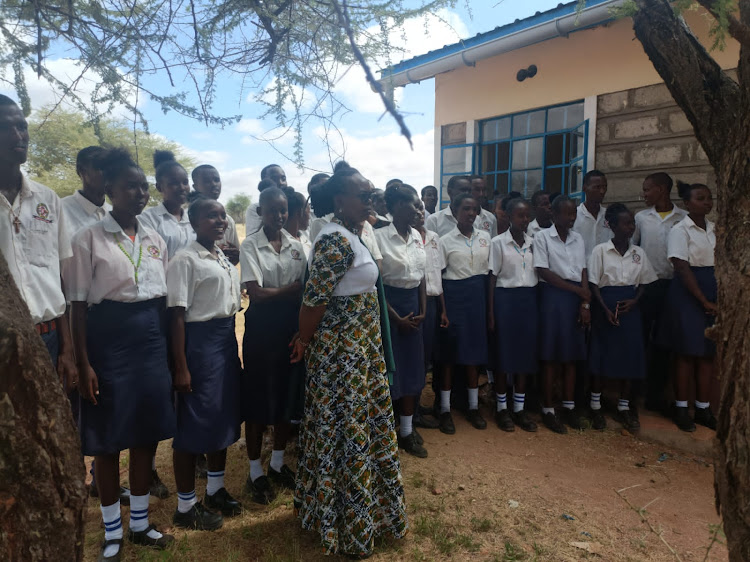 Merrille mixed secondary school's principal Francisca Delea with students while explaining the support the institution gain from the Northern Rangelands carbon project