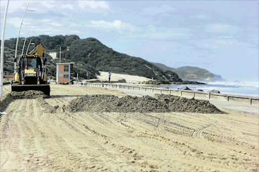 GRADING: A front-end loader clears a stretch of the Esplanade covered by beach sand after massive seas on Thursday Picture: SIBONGILE NGALWA