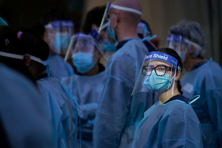 Healthcare workers wait to test residents inside a public housing tower, locked down in response to an outbreak of the coronavirus disease in Melbourne, Australia