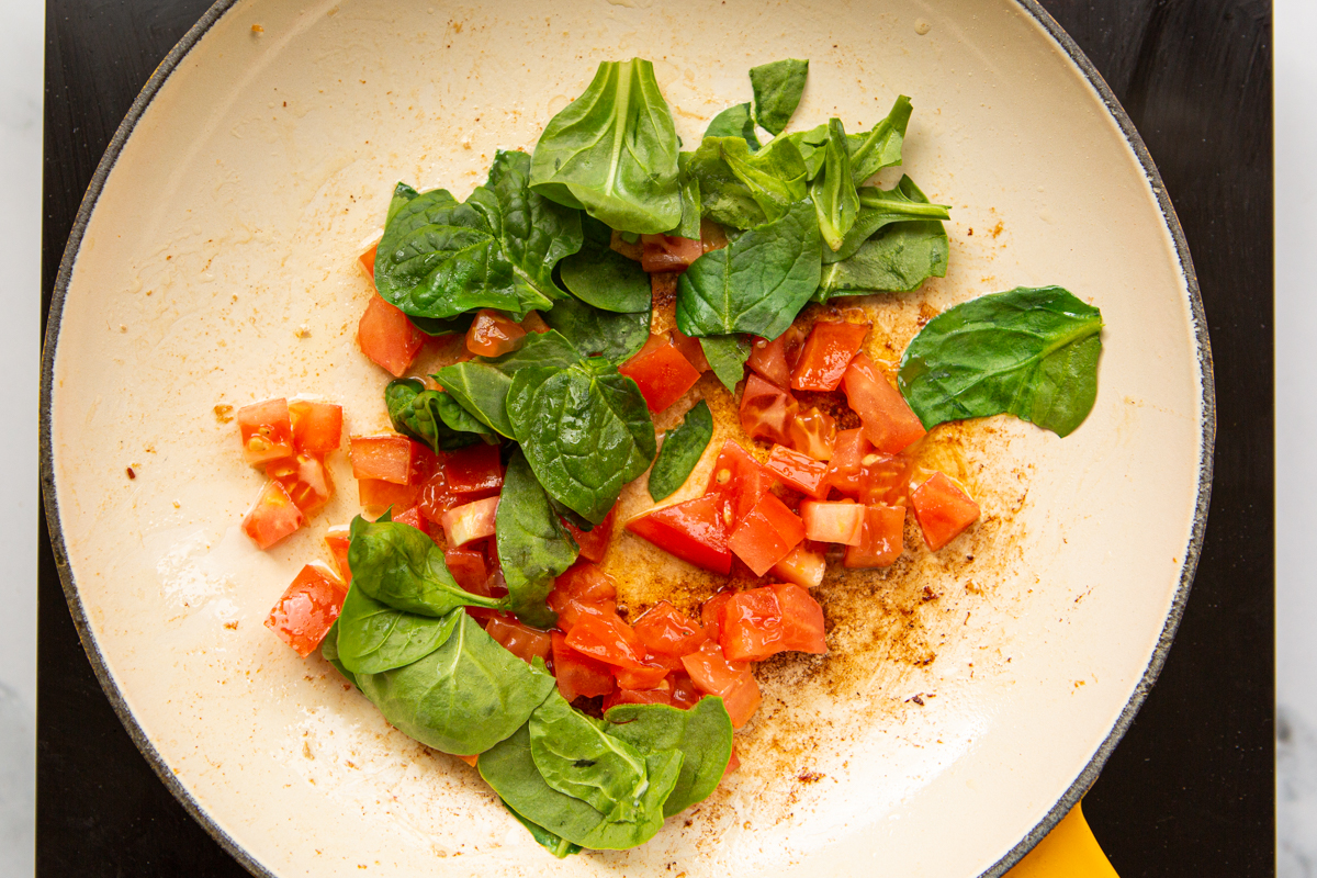 tomatoes and spinach cooked in a skillet