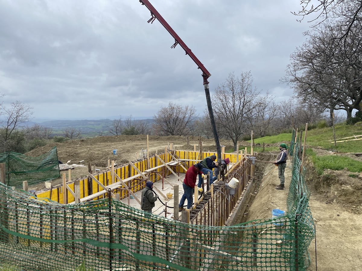 Constructing Santa Pia swimming pool, workman pouring concrete