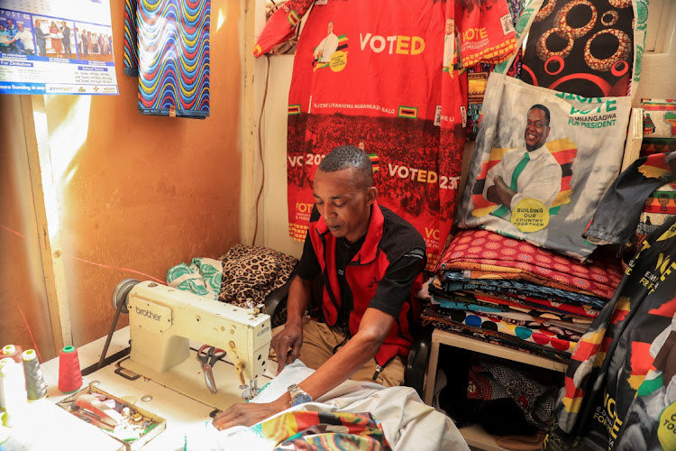 Judah Zunze, a tailor, sews is his workshop in Warren Park in Harare on July 18 2023.