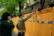 People pass edible oil over the barriers at a street market under lockdown amid the coronavirus disease (Covid-19) pandemic, in Shanghai, China April 13, 2022.