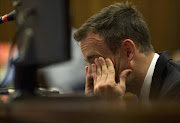 Oscar Pistorius reacts during his trial at the high court in Pretoria April 7, 2014 to Jan Botha's testimony..  REUTERS/Deaan Vivier/Pool