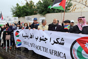 Demonstrators hold a banner during a protest as judges at The International Court of Justice (ICJ) in the Hague, hear a request for emergency measures to order Israel to stop its military actions in Gaza, in Amman Jordan January 11, 2024. REUTERS/Jehad Shelbak