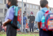 Parents wave goodbye to their kids outside Blomvlei Primary School in Hanover Park, Cape Town.