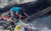 A Palestinian searches under the rubble in the aftermath of Israeli strikes, amid the ongoing conflict between Israel and the Palestinian Islamist group Hamas, in Khan Younis in the southern Gaza Strip, October 14, 2023. 