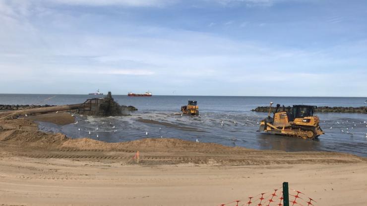 Heavy equipment moving sand on a beach