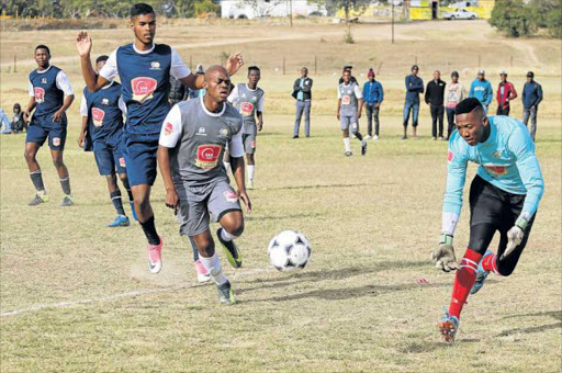 Picture: MICHAEL PINYANA IN THE PRESSURE-COOKER: NMMU Madibaz goalkeeper Xolani Myathaza is in a desperate bid to stop a Bizana Pondo chiefs player during the SAB League playoffs in Alice, as teammates watch anxiously PICTURE: MICHAEL PINYANA