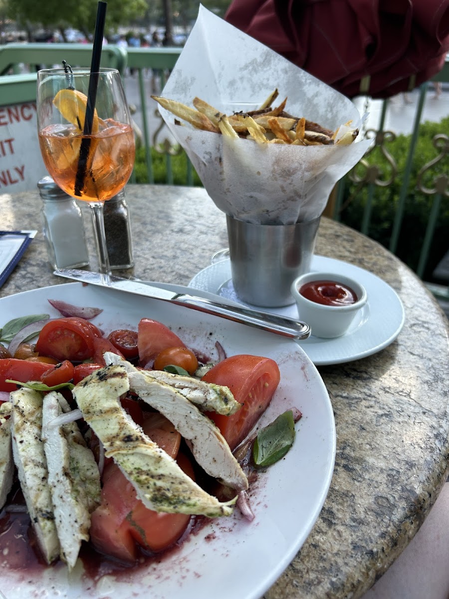 GF/DF tomato/cucumber salad with grilled chicken, frites, and an aperol spritz