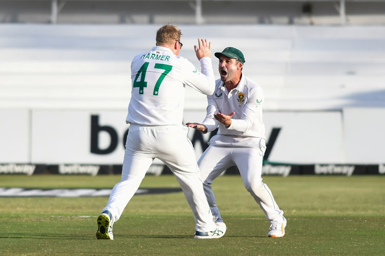 SA's Simon Harmer and captain Dean Elgar celebrate the wicket of Bangladesh's Shadman Islamin at the first Test at Kingsmead in Durban on April 3 2022.