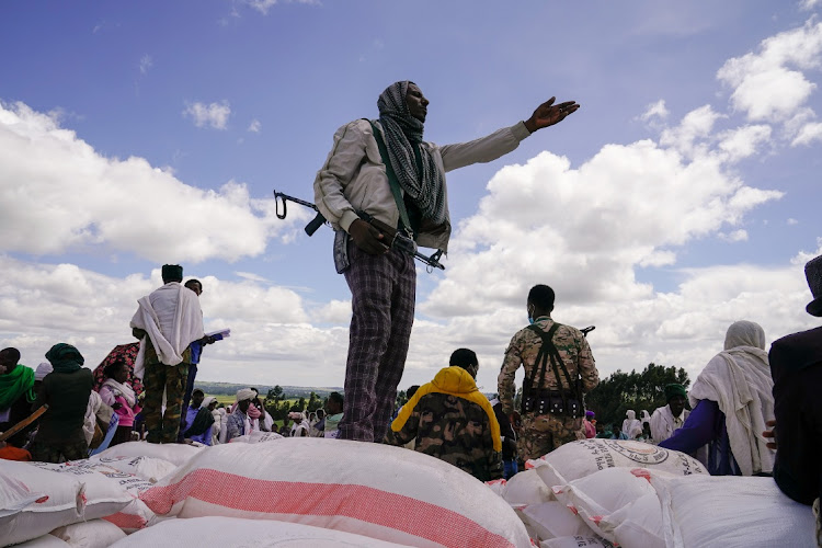 Local guards oversee food aid being delivered to members of the Chena community by the Amhara Emergency Fund during the 40th Day commemoration of the massacre at Chena Teklehaymanot Church on October 10 2021 in Chena, Ethiopia. File photo.