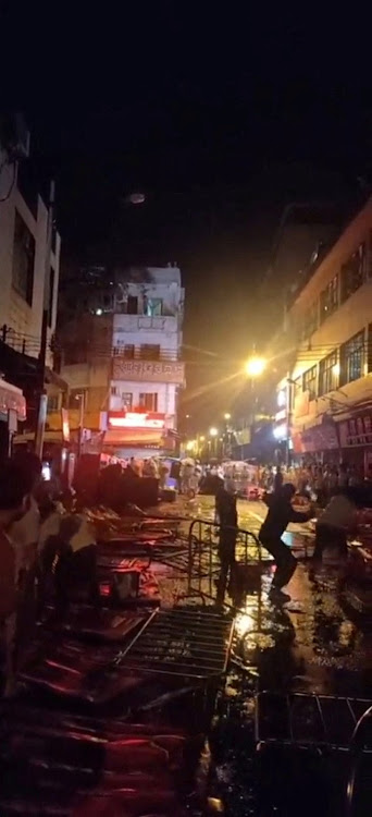 Demonstrators protesting over coronavirus restrictions throw glass bottles towards riot police in Guangzhou, Guangdong province, China in this screen grab taken from a social media video released November 30 2022. Picture: VIDEO OBTAINED BY REUTERS