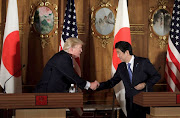 US President Donald Trump (L) shakes hands with Japan's Prime Minister Shinzo Abe. File photo    