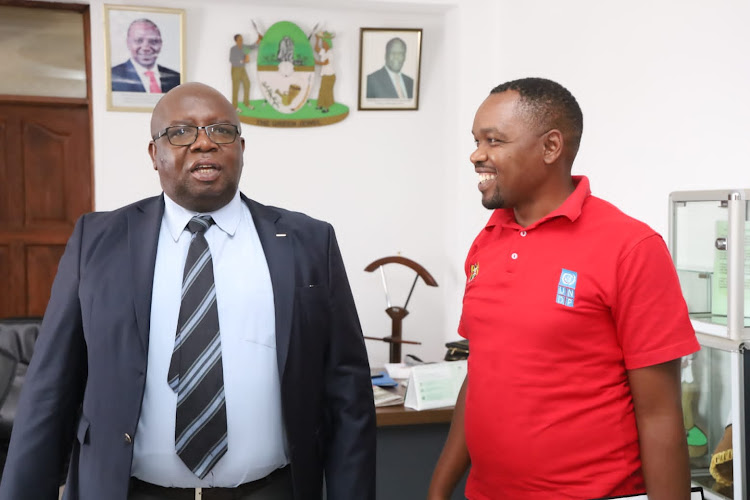 Kakamega county secretary James Ochami with UNDP's Geoffrey Omedo yesterday