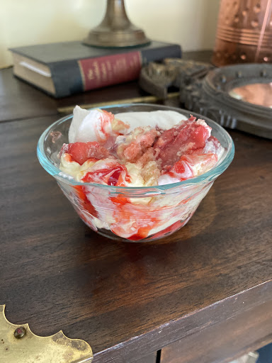 Small glass bowl with strawberries and whipped cream