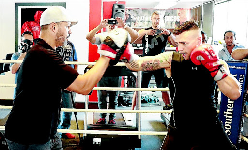 Kevin 'KO Kid' Lerena, right, pads with trainer Peter Smith during their workout in Fourways yesterday. Lerena will face Namibian Vikapita Meroro at Emperors Palace on February 4. PHOTO: Nick Lourens