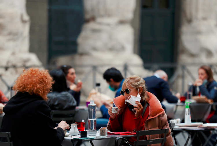 A woman drinks coffee at a terrace of a restaurant as the outbreak of the coronavirus disease continues, in Rome, Italy on October 25 2020.