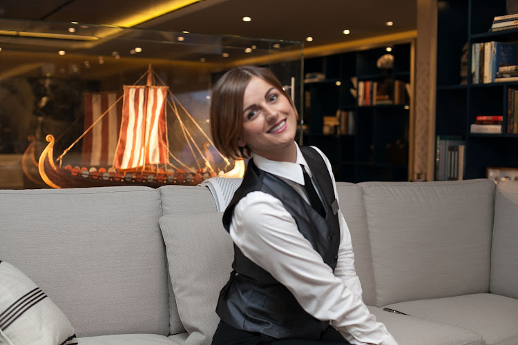 Bar server Ivana Vugovic next to a Viking ship replica in the Explorers Lounge on Viking Star.