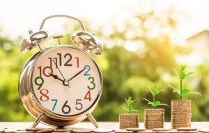 a clock next to the coins with plants