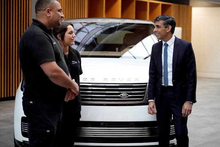 Britain's Prime Minister, Rishi Sunak (right) meets workers during a visit to Land Rover for an announcement on an electric car battery factory in July. Picture: REUTERS
