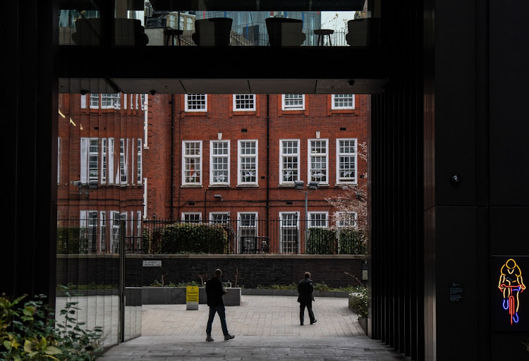 City workers exit an office building in the City of London, UK, on December 14 2021. UK companies added to payrolls in November at a record pace and unemployment fell, figures that are almost certain to fuel concerns at the Bank of England that unsustainable inflation pressures are building in the labour market. Picture: BLOOMBERG/CHRIS J. RATCLIFFE