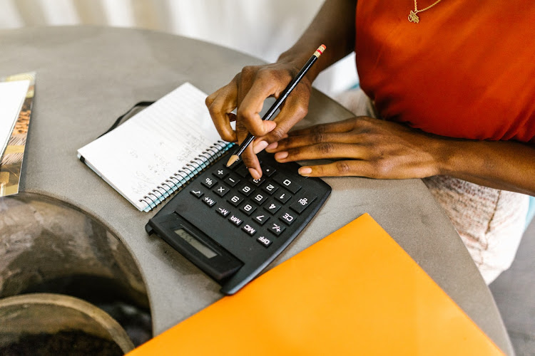 Woman uses calculator to budget