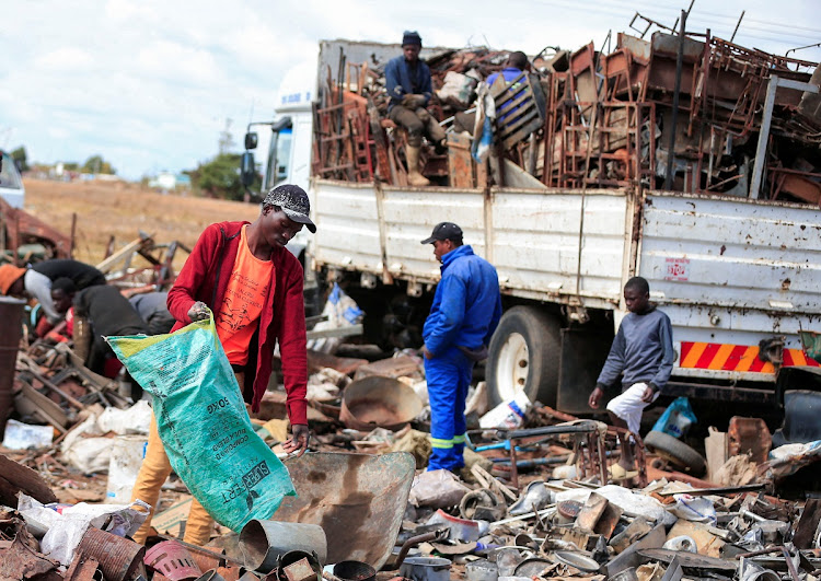 People load scrap metal onto a truck at a collection point in Hopley, a poor settlement about 15km west of Zimbabwe's capital Harare.