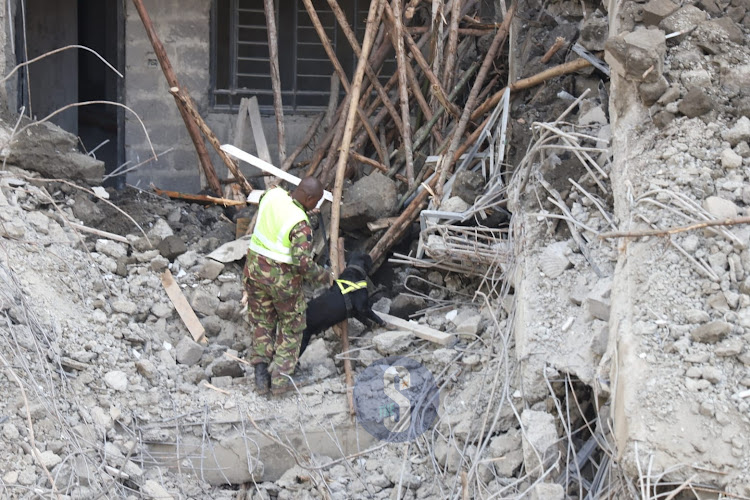 A police dog searches for clues on presence of victims of seven-storey building collapse at Kasarani, Nairobi on November 16, 2022.