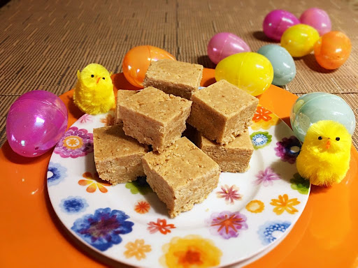 Squared candies on a plate with couple chicks and a bunch of eggs in the background.
