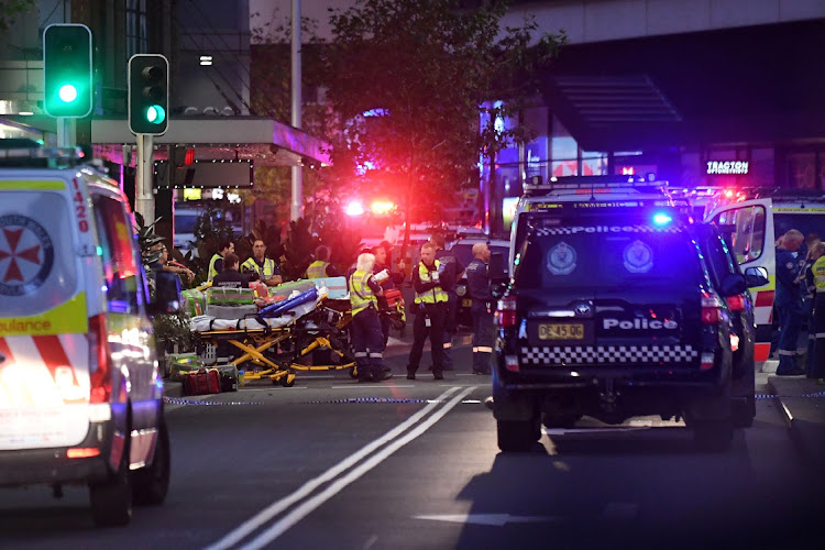 Emergency service workers work near Bondi Junction after multiple people were stabbed inside the Westfield Bondi Junction shopping centre in Sydney on April 13, 2024.