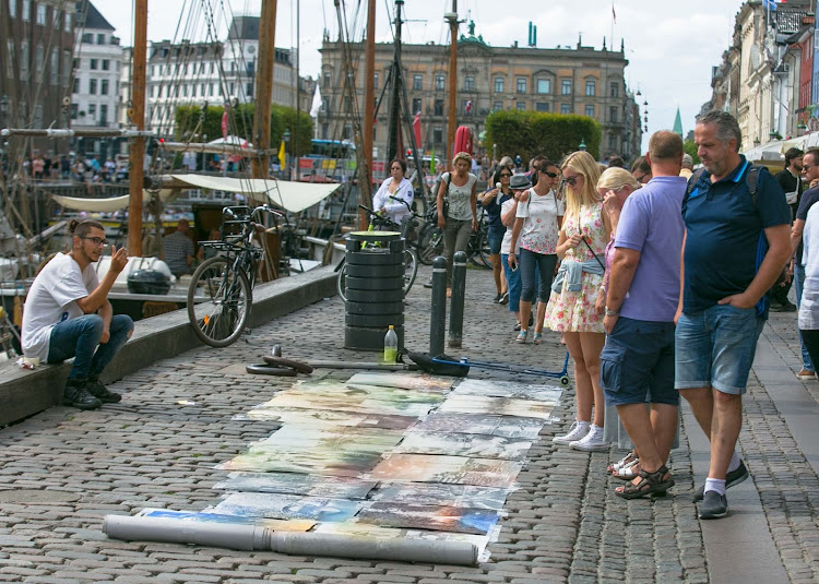 A local artist displays paintings along the canal front in the Nyhavn section of Copenhagen. 