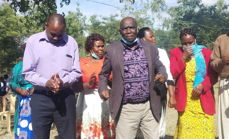 Kandara Residents Association patron Phillip Kamau (middle) joins members in a dance after their meeting in Thika on Saturday