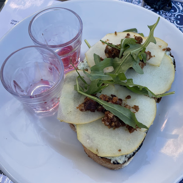 Roasted bread with cheese ricotta, rocket, pear and caramelized nuts