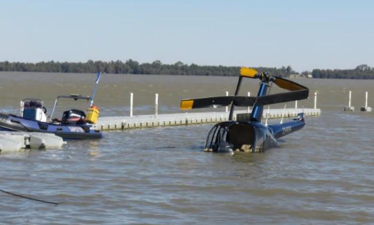 Essie Esterhuysen's wrecked helicopter is pulled ashore after flotation bags raised it from the bed of Vaal Marina.