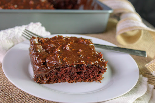 A slice of Sheet Cake That Taste Like Brownies on a plate.