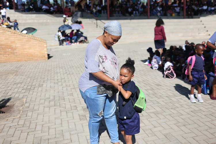 Mother Evelyn Dibaga comforts her daughter, Dinah who is emotional on the first day of grade R, 11 January 2023, at Cosmo City Primary School in Diepsloot, Johannesburg, marking the start of the academic year in primary and high schools.