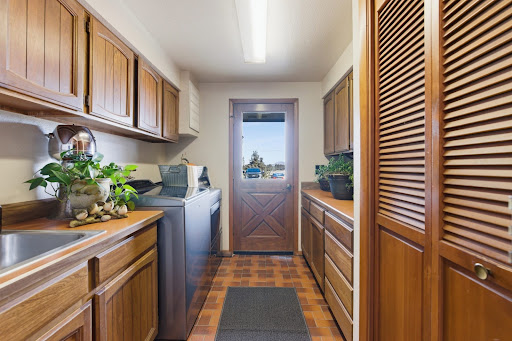 Laundry room with wood cabinets and washer - Buy this luxury house in Redmond, 4 bedrooms