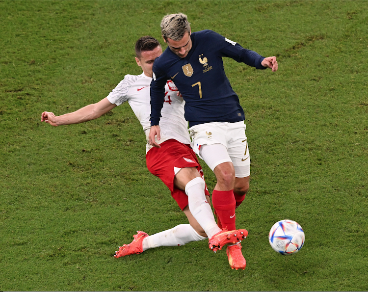 Antoine Griezmann (R) of France vies for the ball with Mateusz Wieteska of Poland at Al Thumama Stadium on December 4