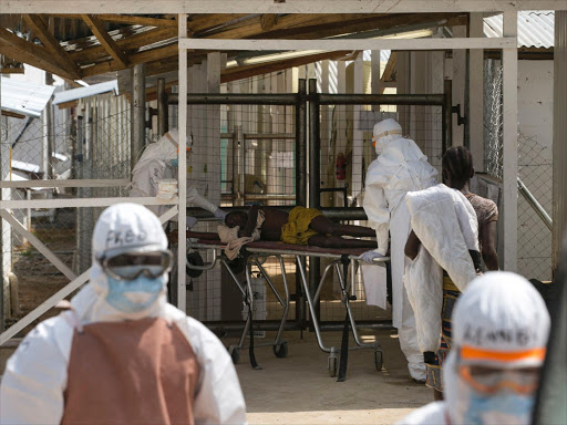 Health workers push a wheeled stretcher holding a newly admitted Ebola patient, 16-year-old Amadou, in to the Save the Children Kerry town Ebola treatment centre outside Freetown, Sierra Leone, December 22, 2014. Photo/REUTERS