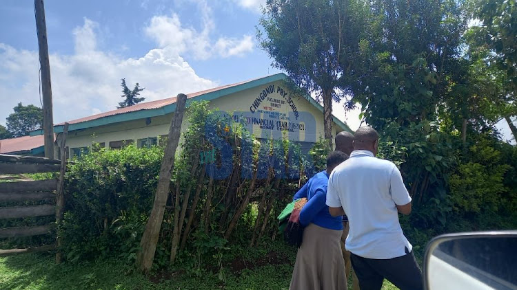 Parents analysing the performance of their pupils outside the gate of Ching'ondi Primary School in Bomet Central on Wednesday March, 30,2022.