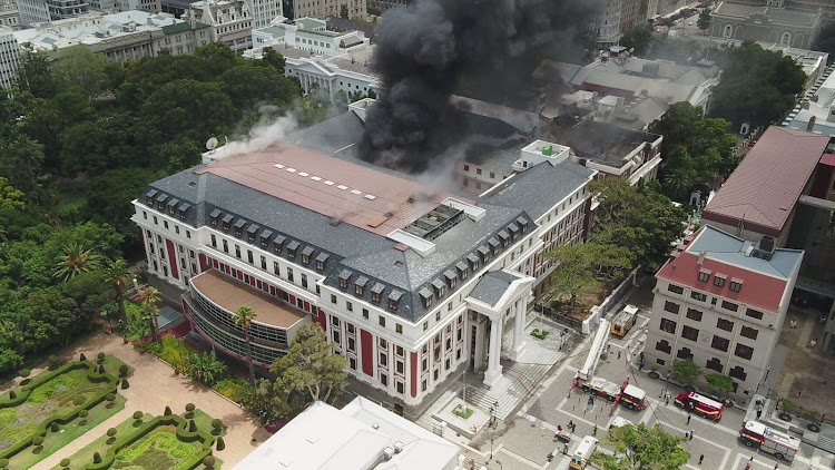 Plumes of smoke from a fire that gutted parts of parliament on Sunday fill the air